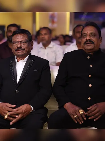 Two gentlemen in our custom formal jackets. One wears a black suit with an embellished lapel, while the other is in a classic black bandhgala jacket.