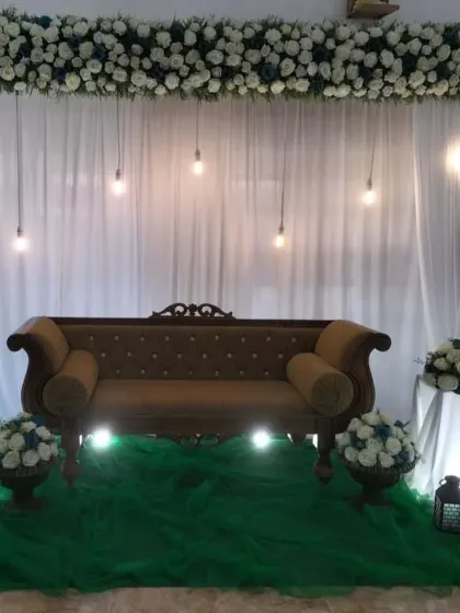 A straight-on view of the stage, showing the symmetrical arrangement of the floral bouquets and lighting.