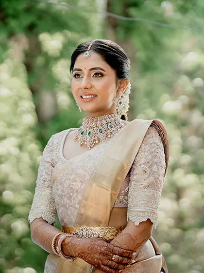 Our lovely client Monisha exudes pure elegance in a subtle gold and beige Kanjeevaram saree. Her custom blouse, with its delicate full-sleeve embroidery, adds a layer of sophisticated craftsmanship to her serene and graceful look.