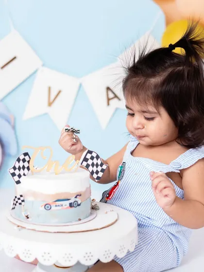 With the checkered flag in hand, he's ready to declare victory over this cake. I love incorporating small props that fit the theme to add another layer of fun to the photos.