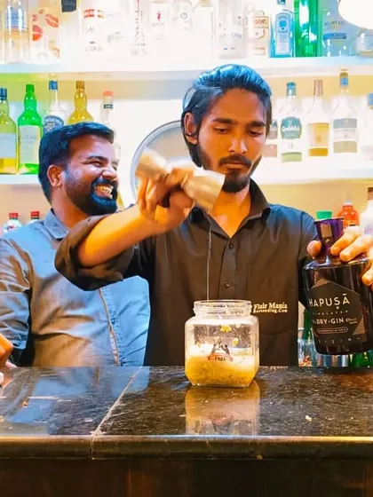 A student learns to make a gin-based cocktail using molecular techniques during a practical class.