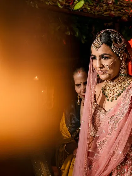 A candid shot of the bride during her entrance, framed by a warm light flare for an artistic touch.