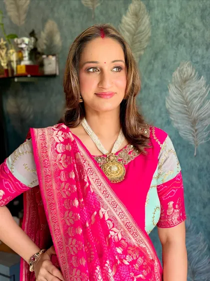 A side profile showing the intricate jewelry and the soft, natural-looking makeup.