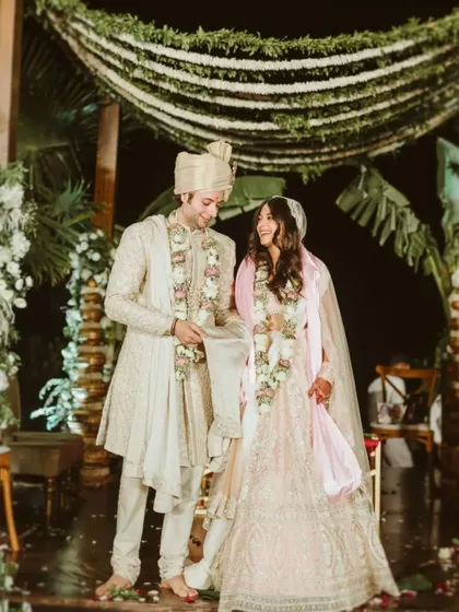 A beautiful portrait of the couple under the mandap, sharing a happy and intimate moment during their ceremony.