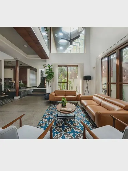 An overall view of the living space, showing the connection between the ground floor, the upper level, and the outdoors. The design emphasizes volume, light, and a natural flow between spaces.
