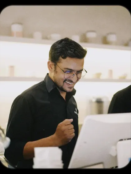 Even our team gets in on the fun! A happy staff member at the counter, enjoying the cafe's vibrant energy.