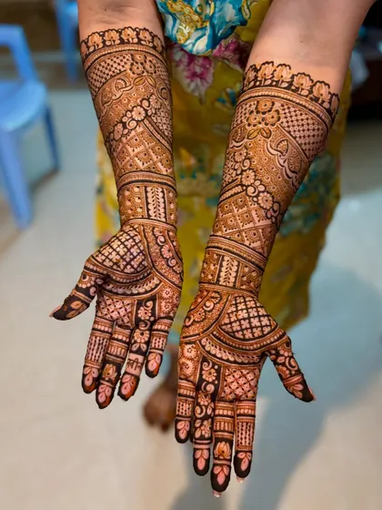 A full-arm bridal design with a mix of dense floral and geometric patterns.