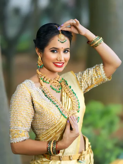 Feel like royalty in this classic golden Kanchi tissue saree. Paired with a heavily hand-embroidered blouse, this ensemble is a timeless choice for a South Indian wedding muhurtham, creating an unforgettable bridal look.