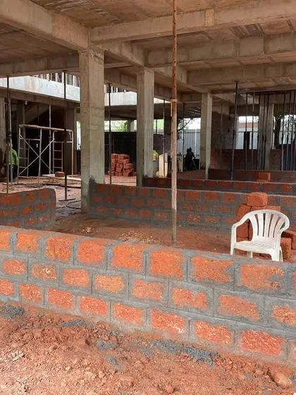 Laterite brickwork begins on the ground floor of the Veerabhavana Villa. This traditional local material is used for infill walls within the concrete structural frame, grounding the home in its Mangalorean context.