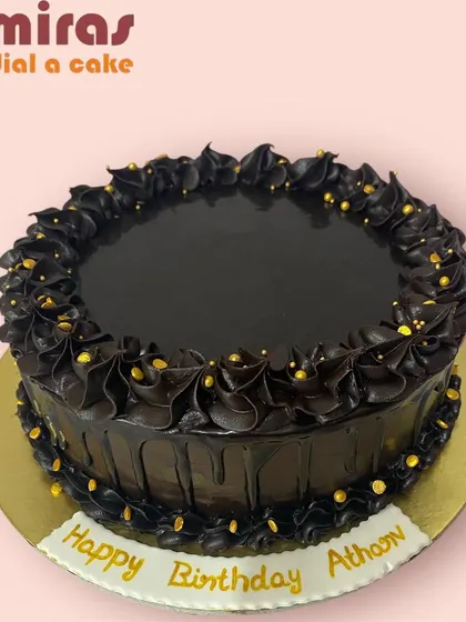 A rich and dark chocolate ganache cake. The glossy ganache and piped swirls are accented with gold sprinkles, making it a simple, elegant, and intensely chocolatey birthday cake.