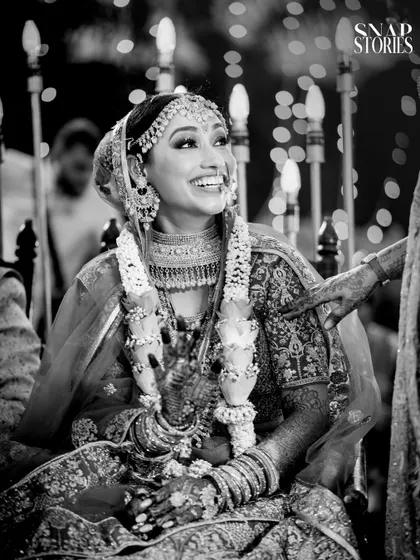 A joyous black and white photo of a bride, her smile lighting up the frame. B&W photography adds a timeless, classic feel to candid moments.