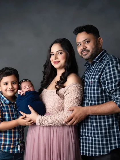 A beautiful family of four, welcoming their new baby girl with love from her big brother.