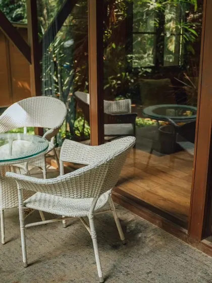 A private patio area outside a chalet, the perfect spot to enjoy a morning coffee surrounded by nature.
