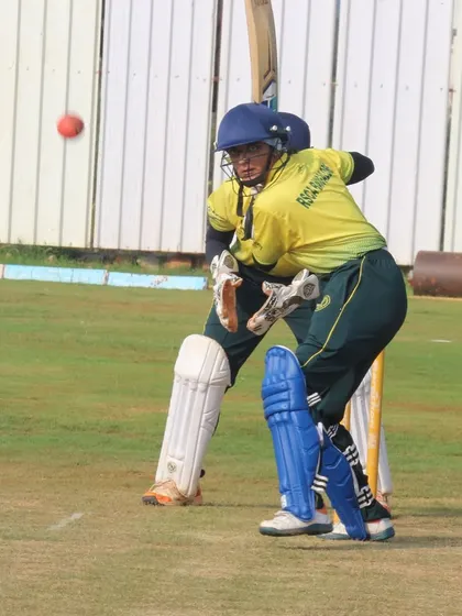 A wicketkeeper and batter in position during a tense moment in a women's match.
