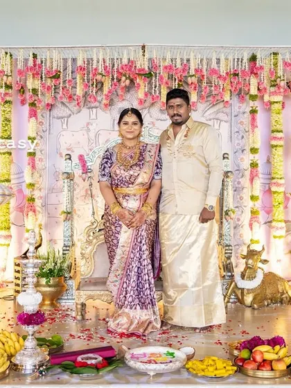 The happy family on stage during their baby's naming ceremony. The grand, traditional decor provides a beautiful and memorable backdrop for their first official family portrait.