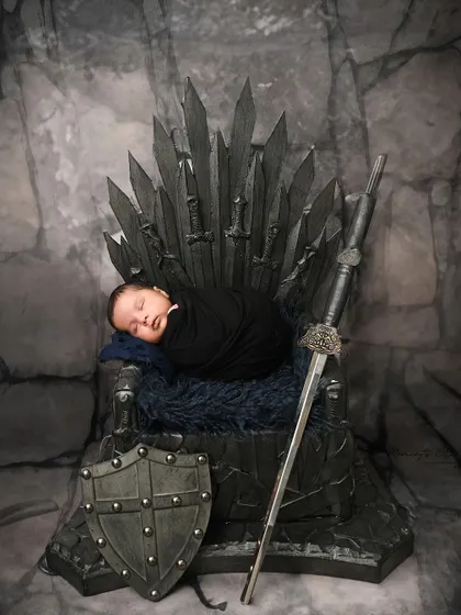 Another take on the epic Game of Thrones theme. This newborn is swaddled in black, sleeping soundly on the iconic Iron Throne.