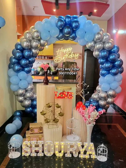 A circular balloon arch in blue and silver set up at home for a birthday celebration.