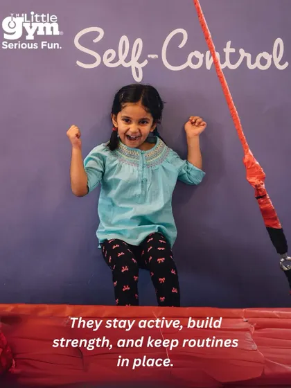 A girl celebrates with fists in the air, a great example of the self-control and strength kids build while staying active in our classes.