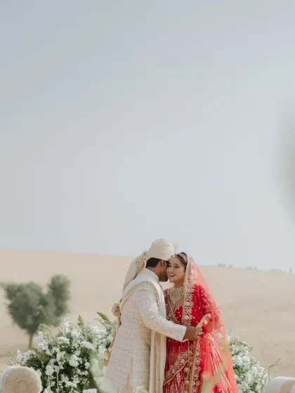 A wide-angle shot capturing the serene and epic scale of a wedding ceremony set amidst the sand dunes of Rajasthan.