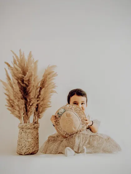 A sweet and shy moment captured during a first birthday session. We use natural-looking props and a soft photography style to create warm and gentle portraits.