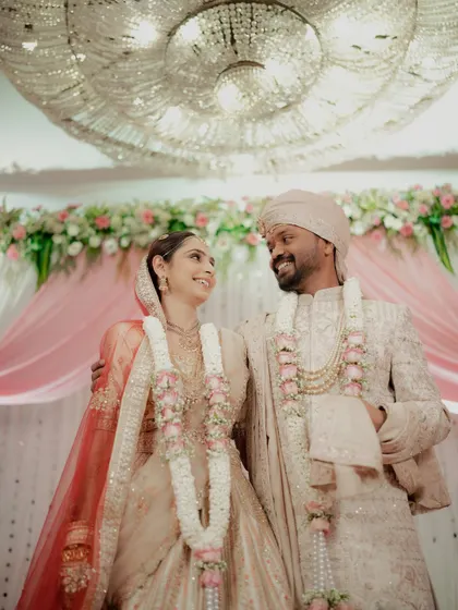 The newly married couple sharing their first look after the rituals, standing under a magnificent chandelier.