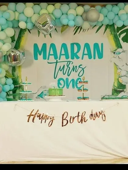 For a more modern and chic celebration, we designed this jungle-themed first birthday. The setup features a clean, custom-designed backdrop, a stylish organic balloon garland in mint and silver, and a dedicated, decorated table for the cake cutting ceremony.