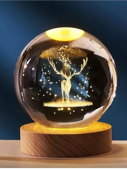 This crystal ball lamp with a glowing deer and stars inside adds a touch of magic to any space. It's an elegant and unique decorative item.