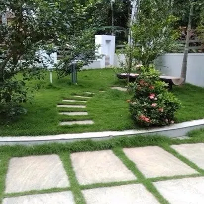 A peaceful garden sanctuary. The combination of a soft lawn, stone pathways, and benches creates a perfect escape from a hectic day.