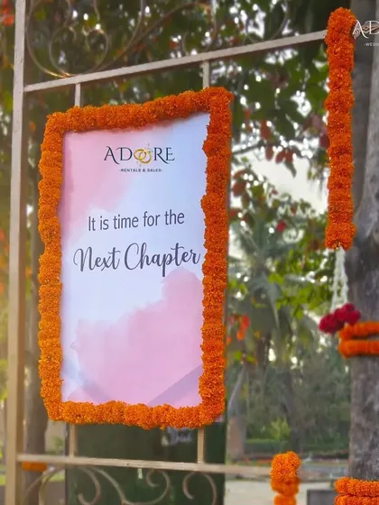 Another take on a welcome sign, this time with a soft, watercolor-style background and the message "It is time for the Next Chapter," framed with vibrant marigolds.