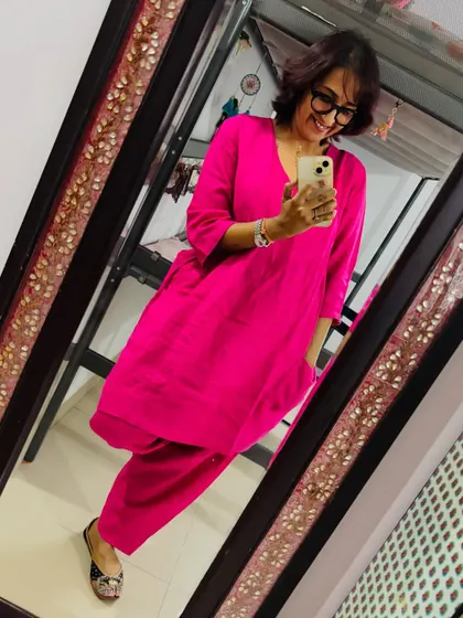A mirror selfie showing off this comfy and chic linen salwar kameez in a vibrant pink. Of course, I had to pair it with my favorite embroidered juttis.