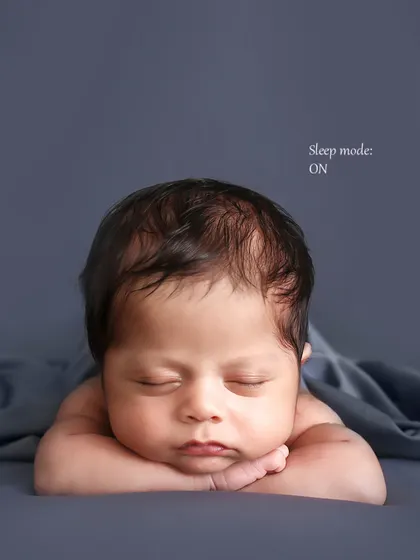 The classic "chin on hands" pose. This adorable position showcases the baby's sweet face and is a favorite among parents for its timeless appeal.