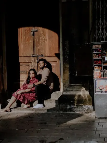 A unique, candid shot capturing the couple in a quiet city corner, with a local street vendor adding authentic Mumbai flavor.