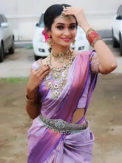 This model showcases a beautiful AD and stone set paired with a lavender saree, perfect for a bridesmaid or guest look.