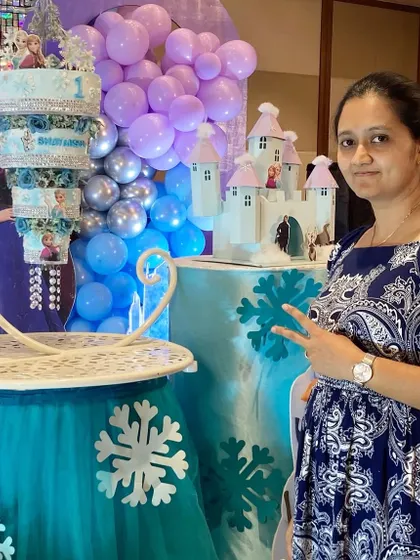 Here I am with the finished Frozen chandelier cake, right before the party started. Seeing the whole setup come together with the decor is one of the best parts of my job.