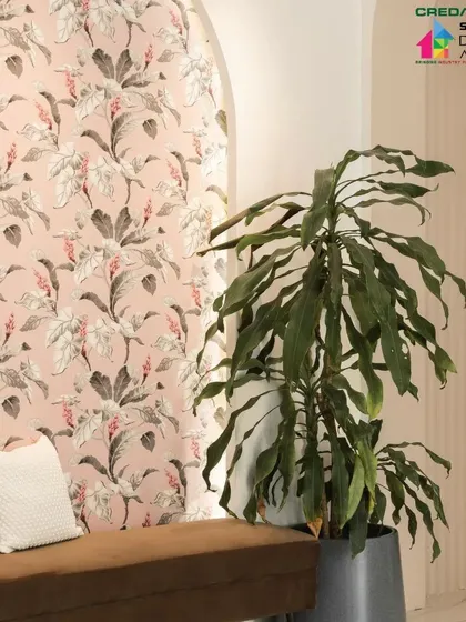 The lush green of the plant contrasts beautifully with the soft pinks and greys of the floral wallpaper.