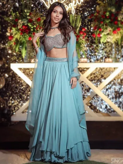 Layering silhouettes with classic minimal embroidery. This client looks radiant in our blue cape-style layered skirt set, a chic and modern choice for any celebration.