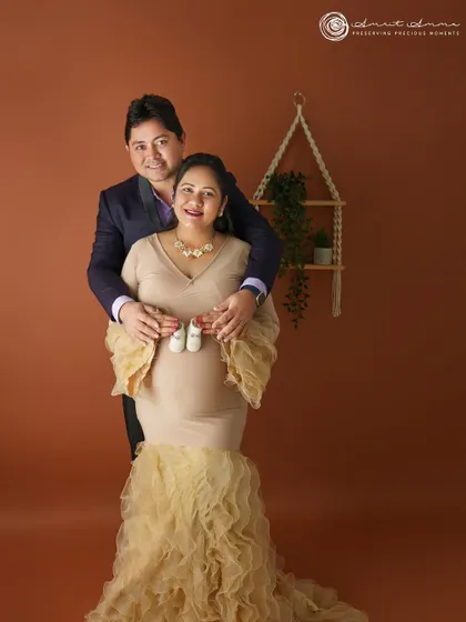 A sweet couple's pose, holding up tiny baby shoes. It’s these personal touches that make a maternity session so meaningful and unique to your story.