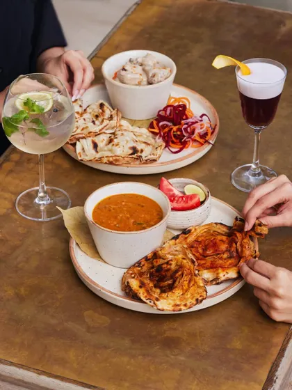 Why choose? A table spread with both our dal makhani and smoked chicken curry, showcasing the variety of our main course offerings.