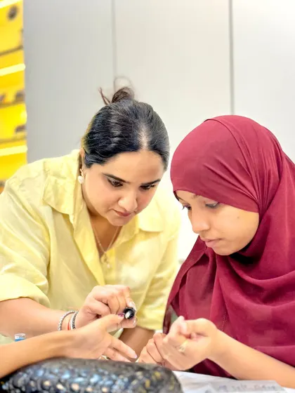 A trainer provides detailed, hands-on instruction to a student. This close interaction ensures that every detail of the technique is understood and mastered.