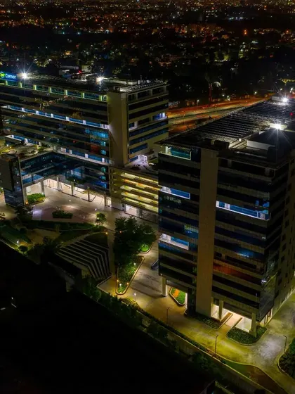 A striking aerial night photograph of a corporate building in Bengaluru. Our low-light drone capabilities allow us to capture the city's architectural landscape with clarity and impact.