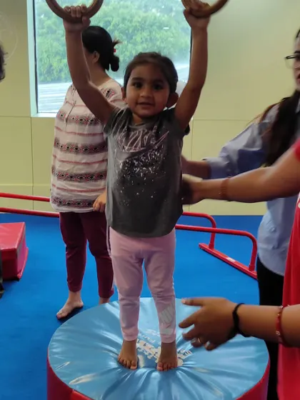 A proud moment for this little gymnast as she stands tall after practicing on the rings. This builds balance and confidence.