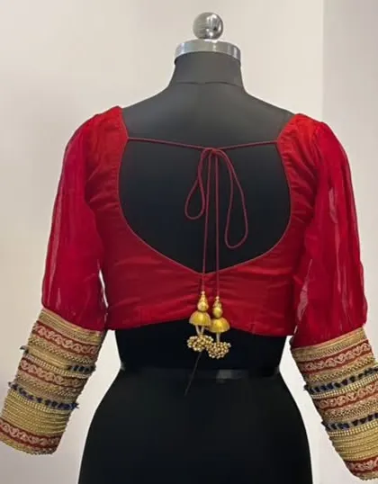 The back of the red velvet blouse, featuring a deep U-neck and elegant tie-up with tassels.