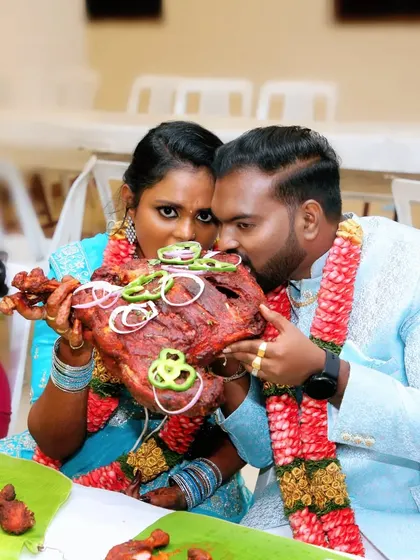 A fun and candid shot of a couple enjoying a whole roasted chicken at their wedding feast. These are the moments we cherish.