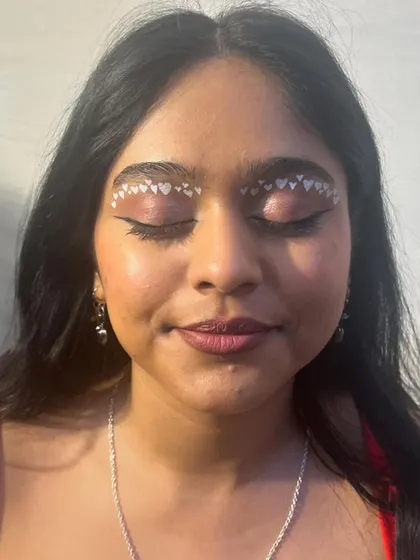 A sweet and playful look using tiny heart-shaped stickers to create a unique eyeliner effect. This is perfect for a fun, themed event or photoshoot.