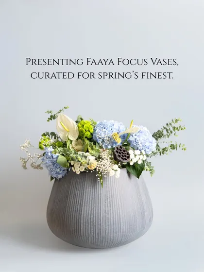 A grey, textured vase from our Faaya Focus collection, curated for spring's finest blooms. The cool tone of the vase provides a perfect contrast to the soft blues and greens of the hydrangea arrangement.