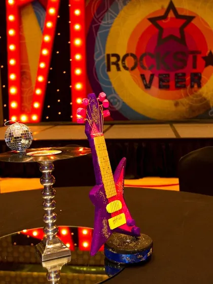 The main stage for our "Rockstar Veer" party. The custom backdrop and themed centerpiece with a miniature guitar and disco ball made every guest feel like they were at a real concert.