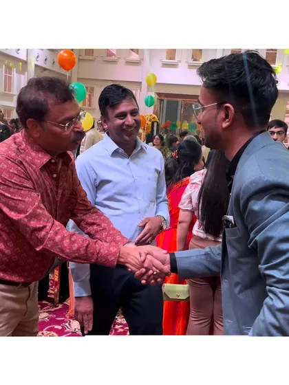 Shaking hands with a guest after a performance. Building rapport is just as important as the trick itself.