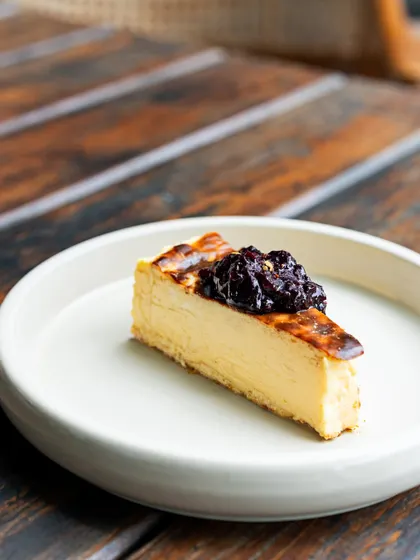 A perfect slice of my Basque Cheesecake, topped with a sweet berry compote. The cheesecake has a beautifully caramelized top and a creamy, melt-in-your-mouth interior. It's simple, elegant, and incredibly satisfying.
