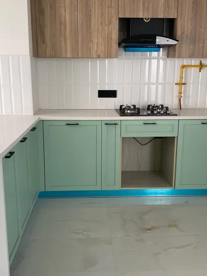 A beautiful pistachio-green kitchen transformation. This image shows the finished lower cabinets and the white subway tile backsplash, creating a fresh and cheerful cooking space.