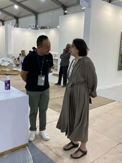 A candid moment of conversation during the busy art fair setup.